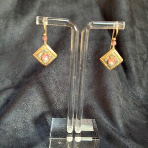 Dangling gold tone earrings with pink and green flowers.